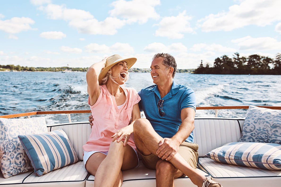 a middle-aged couple relaxes on their boat, enjoying the sun and the open water