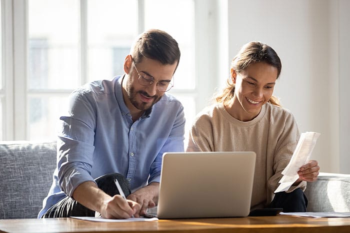 A couple logs into their credit union online banking platform to manage their finances.